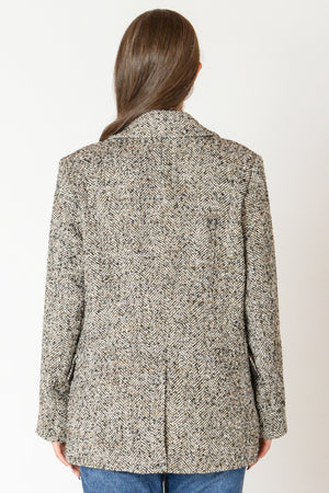 Back view of woman wearing a tweed blazer.