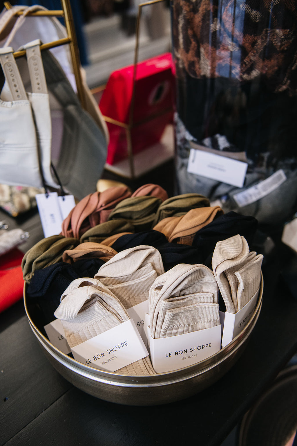 A collection of ribbed socks displayed in a bowl, with various colors including black, beige, and green.
